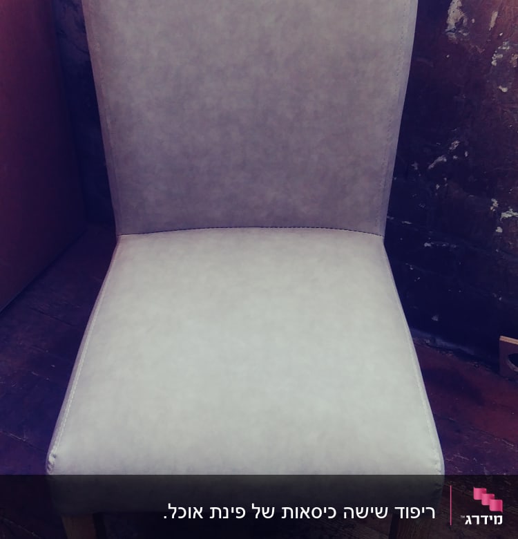 כיסא מרופד בבד אפור על רצפת עץ